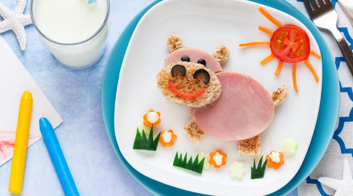 Mini sendviči u obliku životinja ženska osoba za radnim stolom jede hamburger
