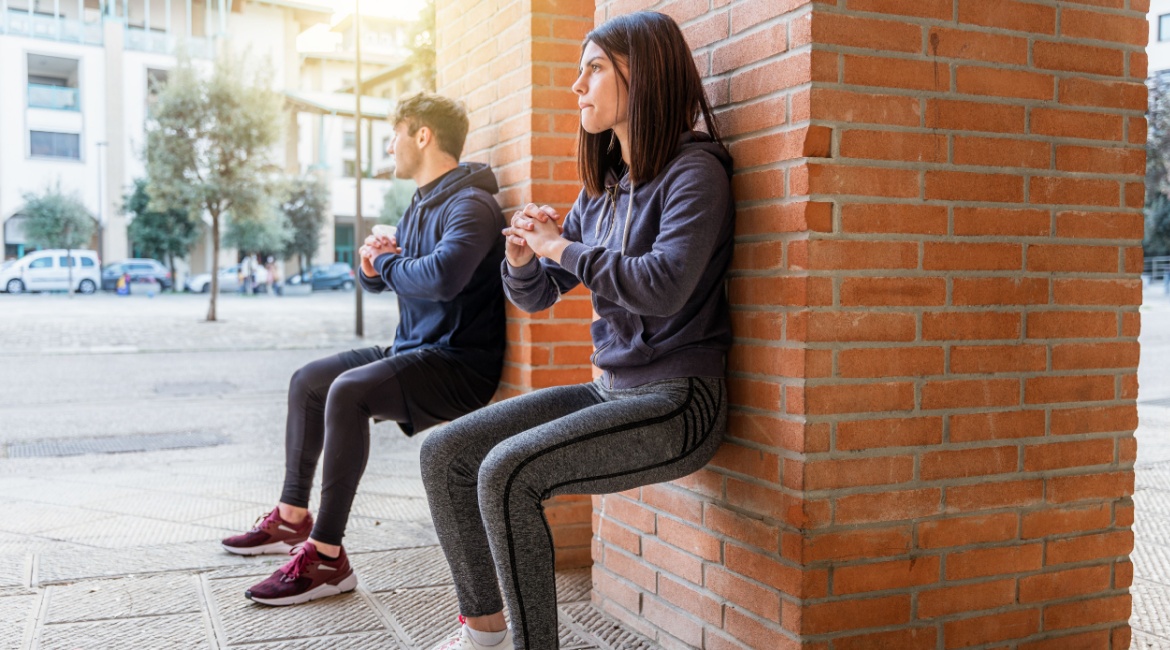 Wall Squats ženska osoba za radnim stolom jede hamburger